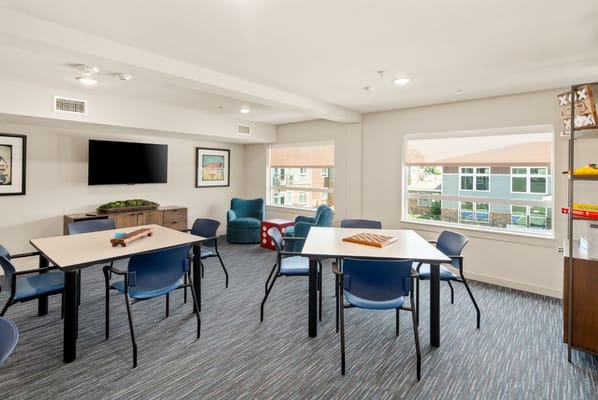 Common area with tables and chairs in a bright room