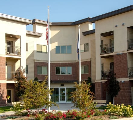 Exterior view of the entrance with flags and landscaping.