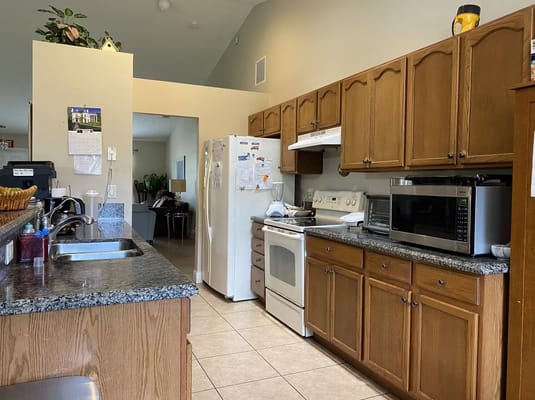Bright kitchen area with wooden cabinets and appliances