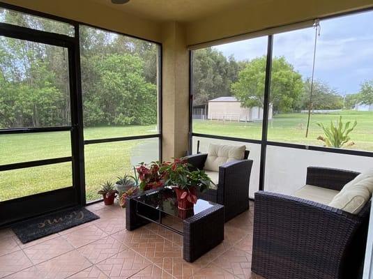 Screened-in porch with seating and greenery