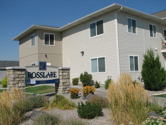 Exterior of Rosslare Senior Apartments with landscaping and sign