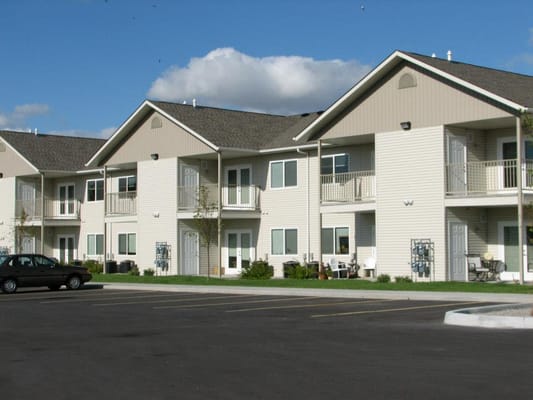 Exterior of Rosslare Senior Apartments with parked cars