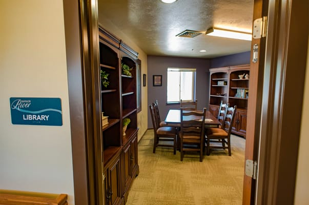 View of a library area with seating in a senior living facility