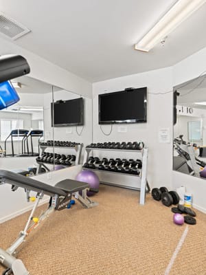 Inside view of a fitness room with weights and exercise equipment