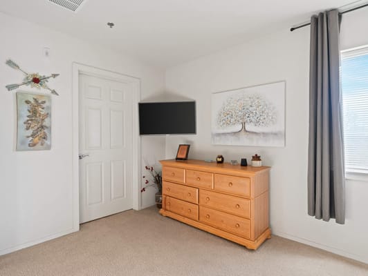 Cozy resident room with a dresser and TV