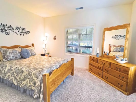 Cozy private bedroom with light decor and a mirror