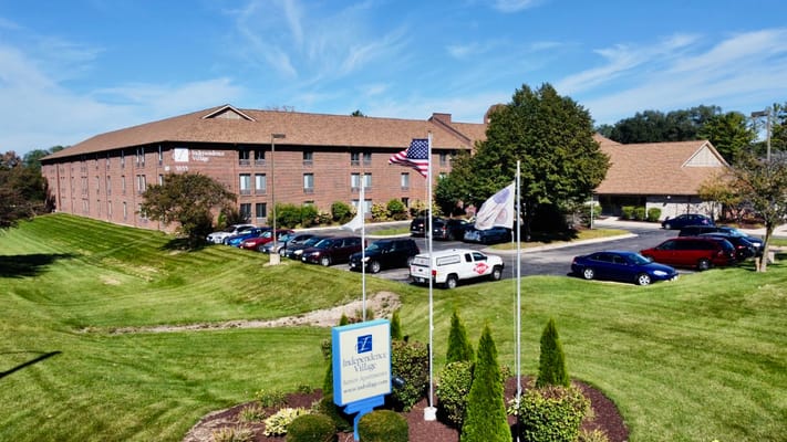 Exterior view of Independence Village of Rockford with flags and landscaping