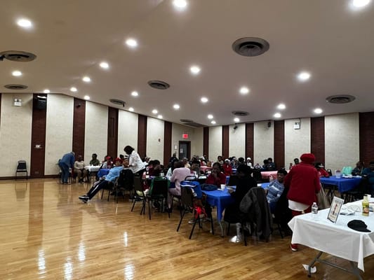 A social event with attendees seated at tables in a well-lit room.