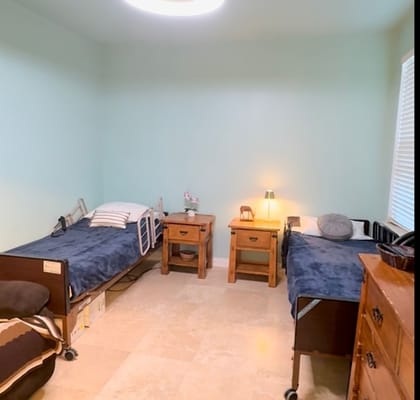 A shared bedroom with two beds, bedside tables, and soft lighting.