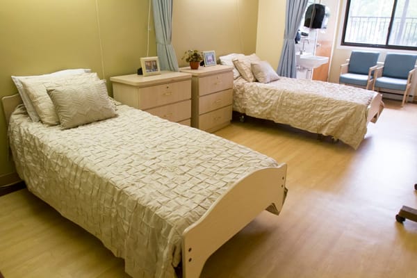 Two beds in a cozy bedroom setting with wooden furniture