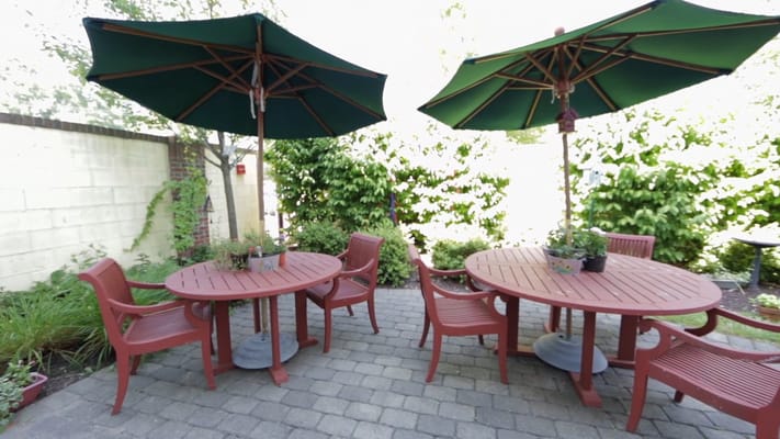 Patio area with tables and umbrellas in a garden