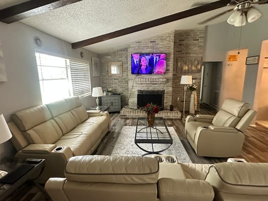 Spacious living room with cream-colored sofas and a TV