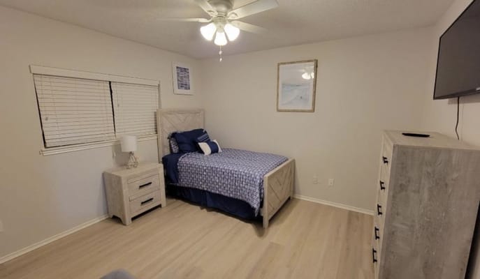 A cozy bedroom with a bed, nightstand, and dresser