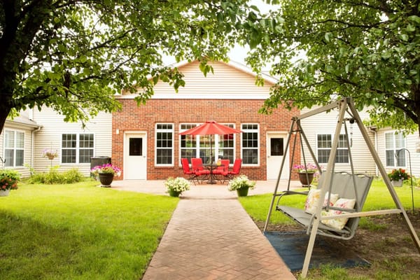 Outdoor seating area with red umbrella and swing