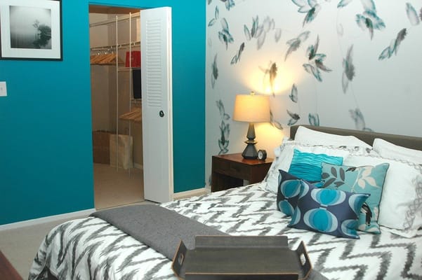 A well-decorated bedroom with a stylish bed and a closet entry