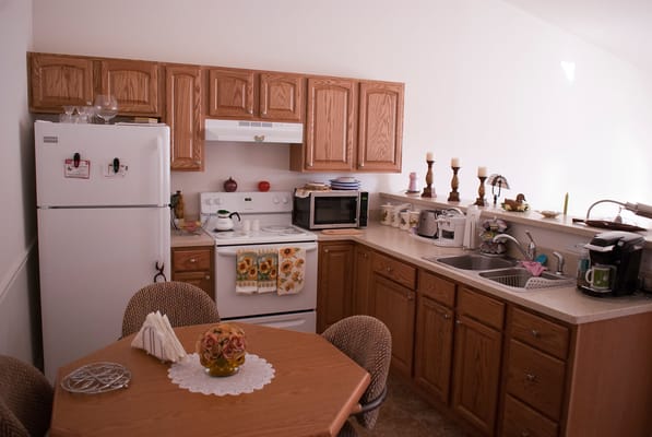 A cozy kitchen area with wooden cabinets and dining table