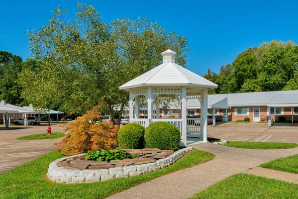 White gazebo surrounded by greenery at Leisure Living