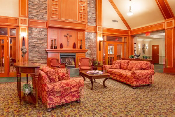 Comfortable living room with red floral sofas and a fireplace