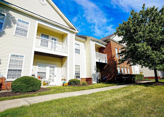 Exterior of The Gallery Apartments with green grass and trees