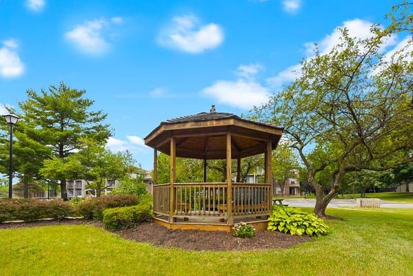 A wooden gazebo surrounded by greenery