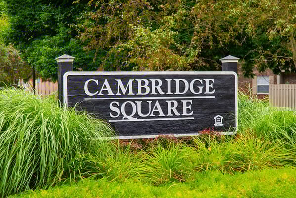 Signage of Cambridge Square Apartments surrounded by greenery