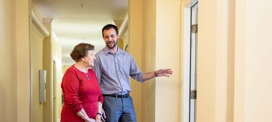 Staff member engaging with a resident in a hallway