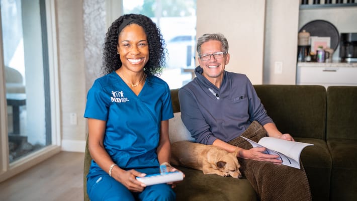 A nurse and a resident smiling together in a cozy living area