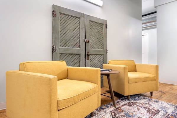 Cozy seating area with yellow chairs and decorative door