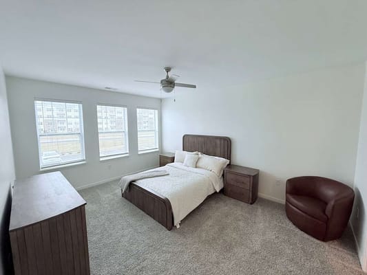 Spacious bedroom with large windows and modern furniture