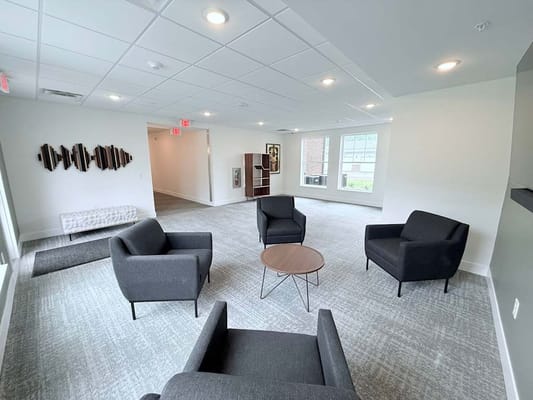 Spacious common area with gray chairs and a round table