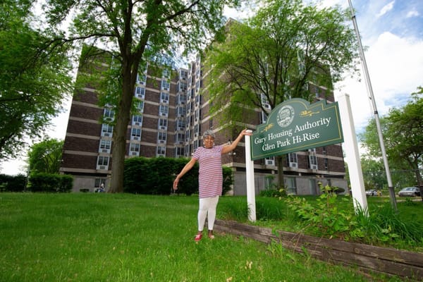Resident standing by the Glen Park Hi-Rise sign