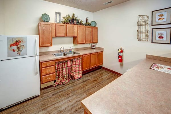 Bright kitchen area with cabinetry and decor