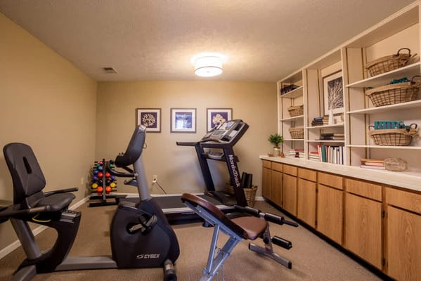 Fitness room with exercise equipment and shelves