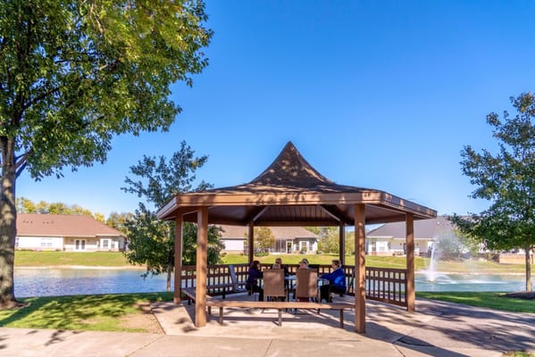 Residents enjoying a gazebo by the pond