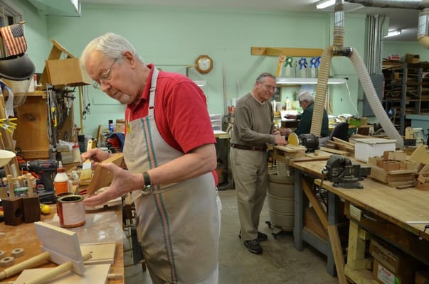 Residents engaged in a woodworking activity in a workshop