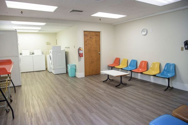 Interior view of a common area with seating and laundry facilities
