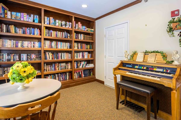 Wooden shelves filled with books and an organ in a library