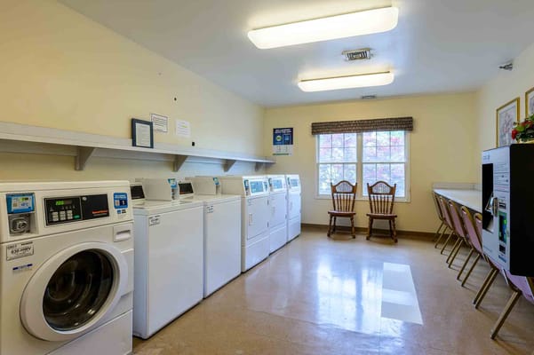 Bright laundry room with washing machines and seating area