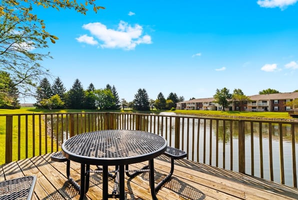 Outdoor seating area by a serene pond