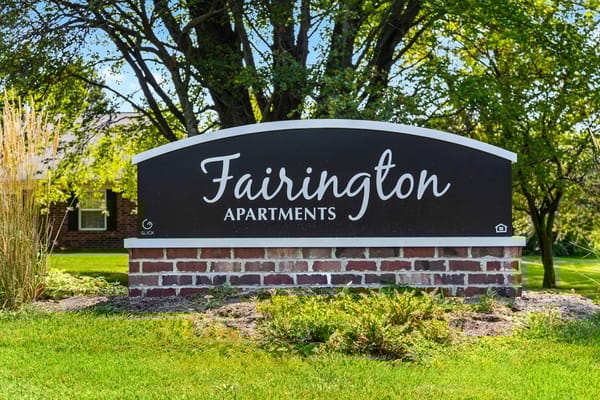 Sign for Fairington Apartments surrounded by greenery