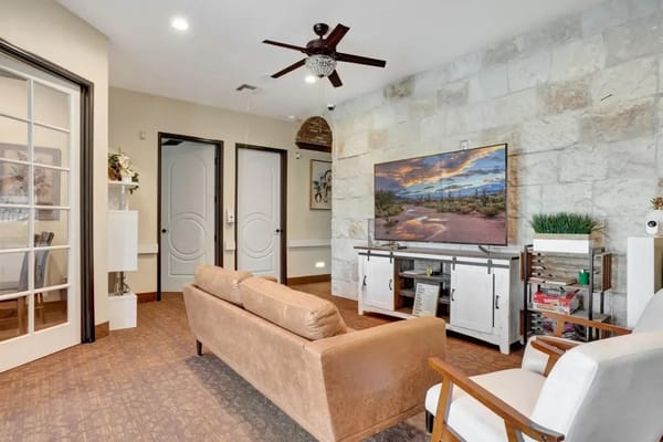 Common area with seating and a TV in a senior living facility