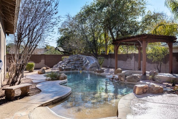 Outdoor swimming pool area with landscaping and seating