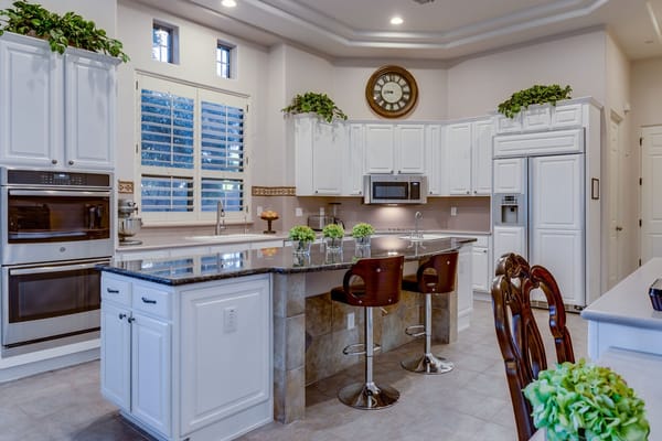 Modern kitchen area with white cabinetry and seating