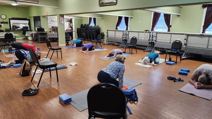 Residents participating in a yoga class in the activity room
