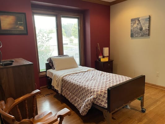 A cozy interior of a resident room with a bed and furniture.