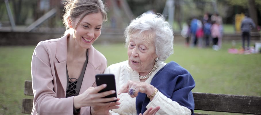 A caregiver and senior woman sharing a moment outdoors