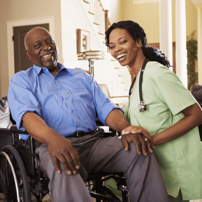A caregiver smiling with a resident in a living room