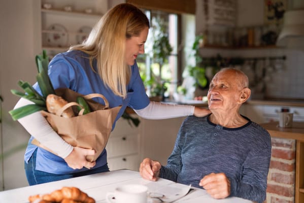 Caregiver interacting with a senior over groceries