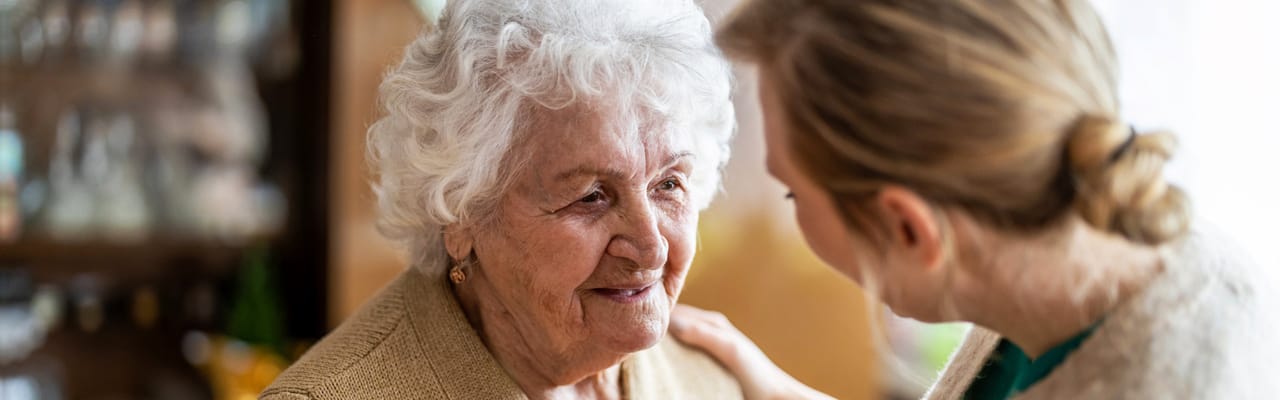 Resident and caregiver interacting with warm smiles
