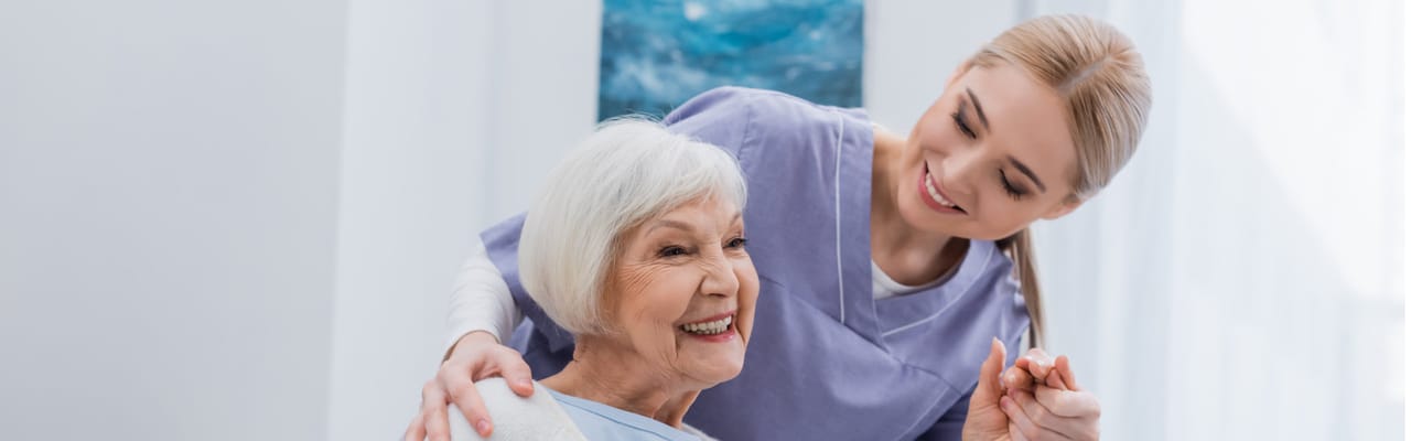 Caregiver interacting with a senior resident in a bright room